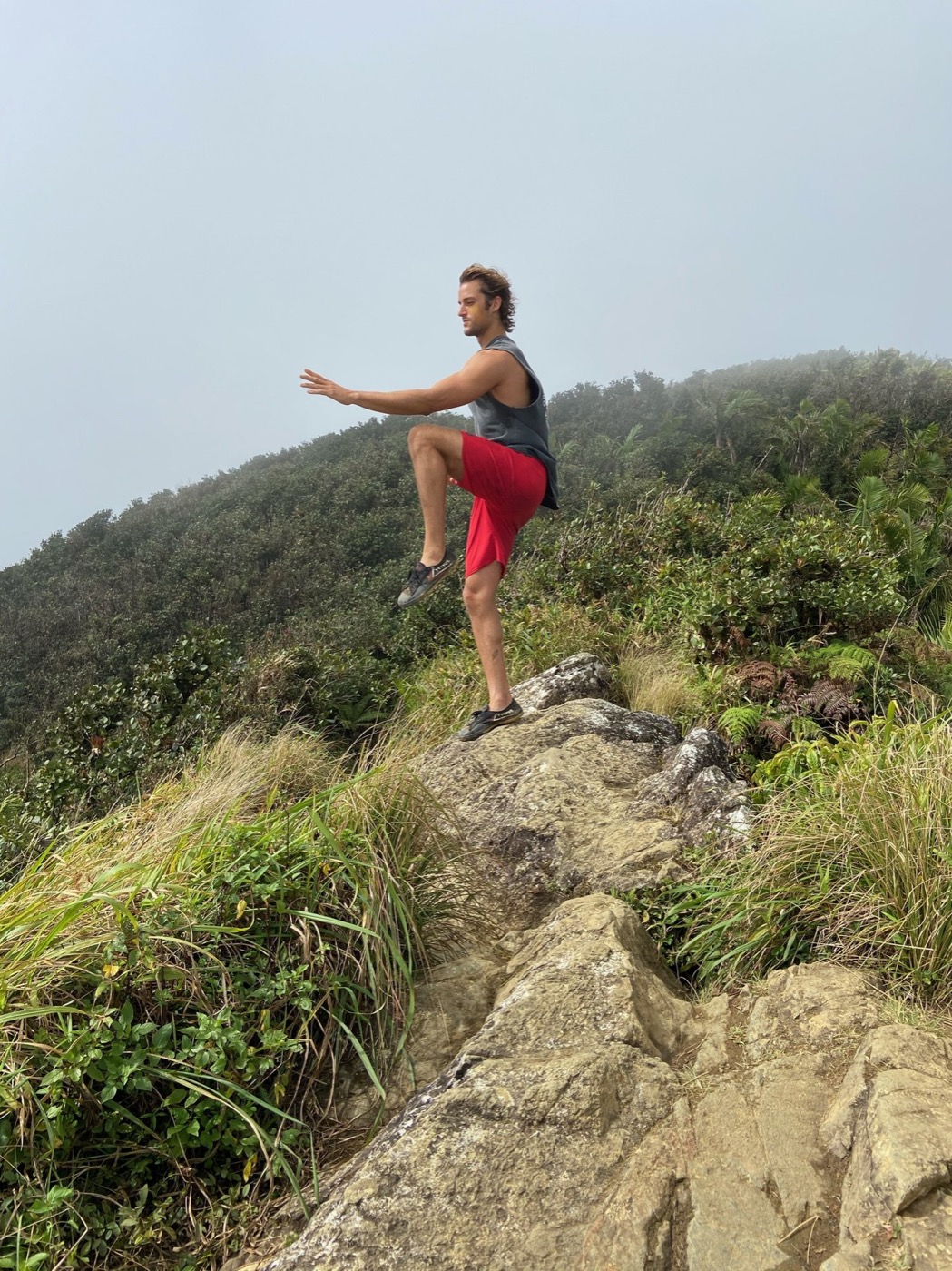 Mark Poli in a single-leg movement stance on a mountain ridge in Puerto Rico